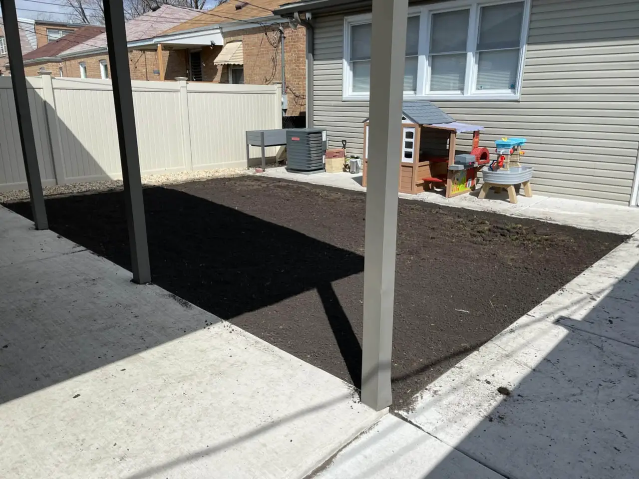Freshly graded soil bed prepared for new sod along a home