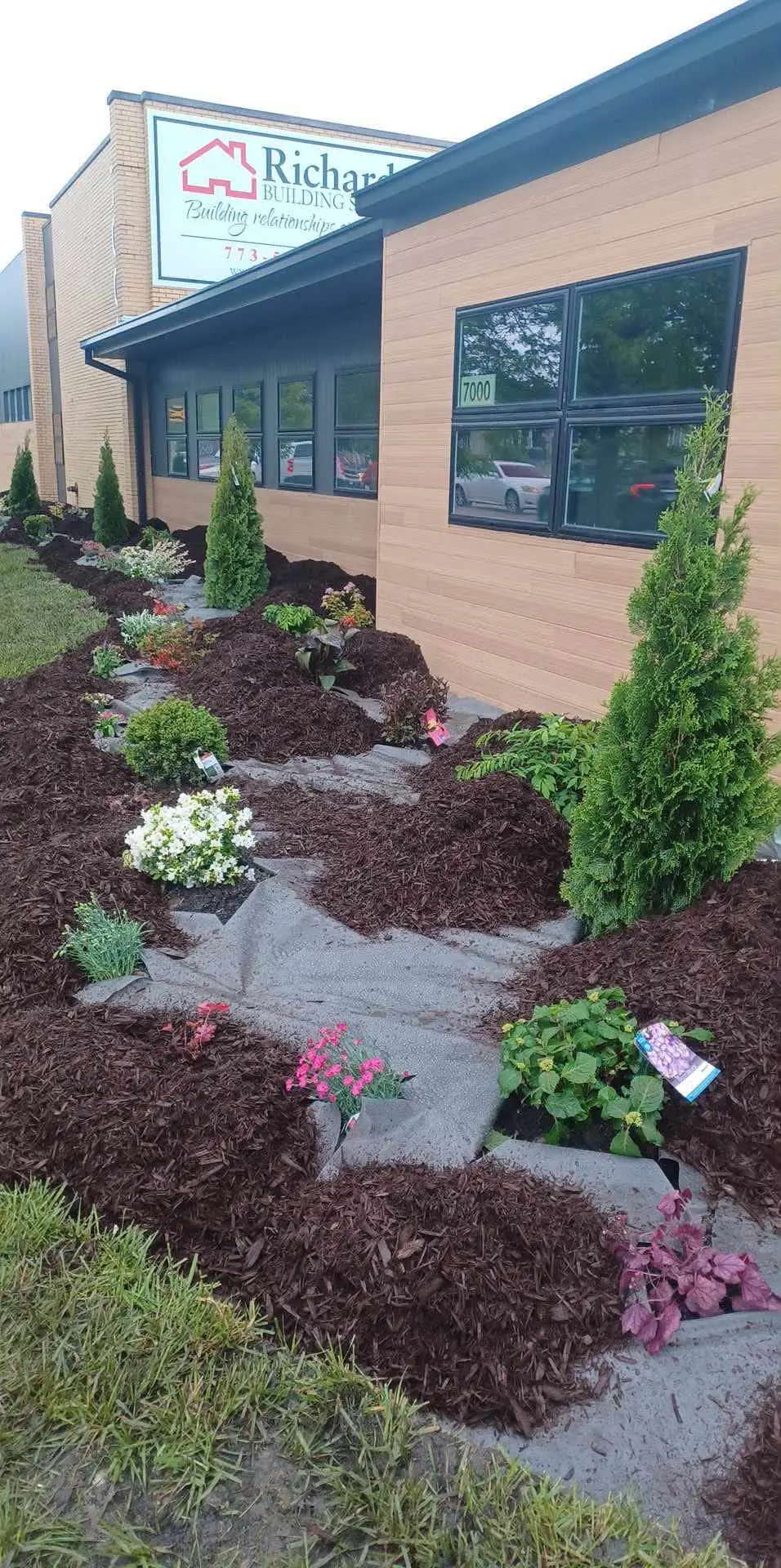 Commercial building landscape bed with mulch, stone path and fresh plantings
